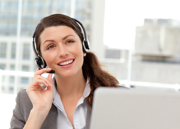 Foto mulher de negócios pensativa falando ao telefone enquanto trabalha no computador