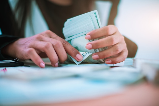 Foto mulher de negócios que conta notas do dólar americano.