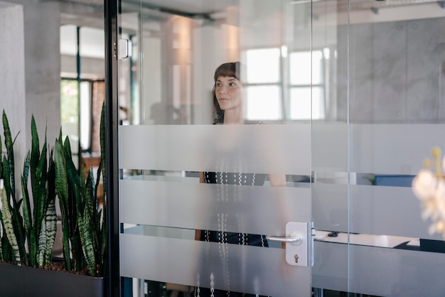 Foto mulher de negócios que está atrás da porta de vidro