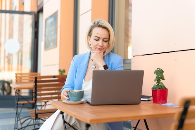 Mulher de negócios rosto bonito caucasiano jovem ou maduro profissional de carreira chefe de terno de negócios trabalhando usando laptop mulheres modernas empreendedora trabalhando em restaurante e café pequenas empresas