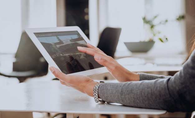 Mulher de negócios segura um tablet nas mãos.