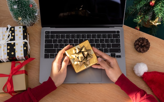 Mulher de negócios segurando a caixa de presente na mesa do escritório no dia de Natal.