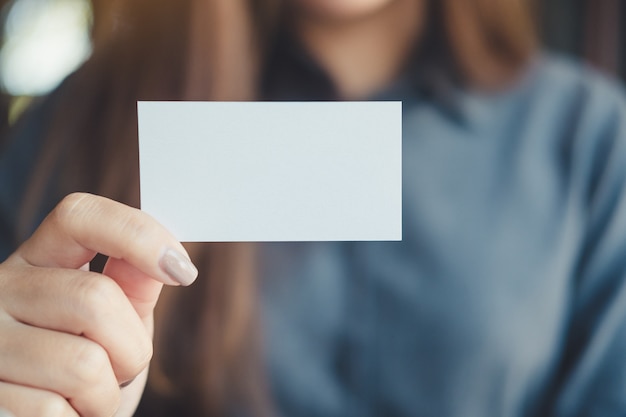 Mulher de negócios segurando e mostrando o cartão vazio no escritório