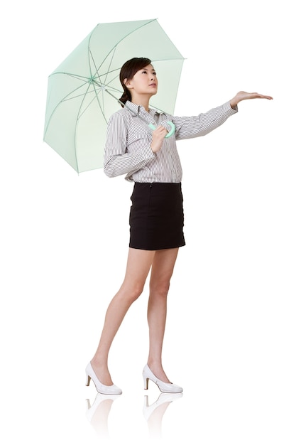 Mulher de negócios segurando guarda-chuva verde, isolado na parede branca.