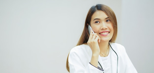 mulher de negócios, segurando o smartphone e falando no escritório