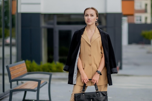 Mulher de negócios segurando uma bolsa de laptop indo para o escritório Exibição de empresária em edifícios modernos na cidade