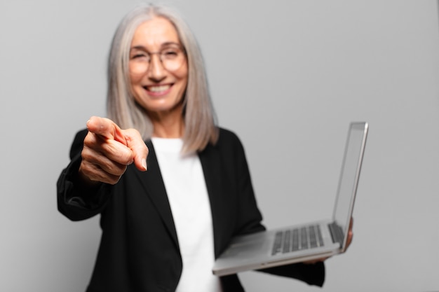 Mulher de negócios sênior bonita com um laptop