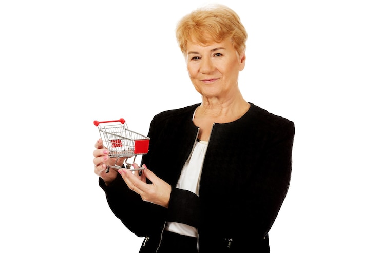 Foto mulher de negócios sênior segurando carrinho de compras contra fundo branco.