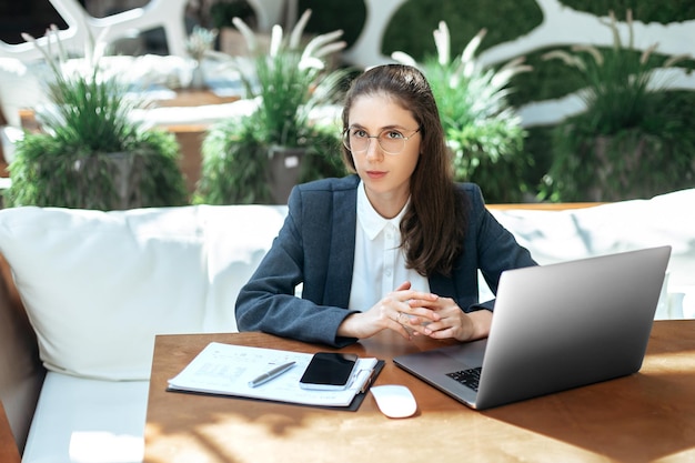 Mulher de negócios sentada em um laptop em um café