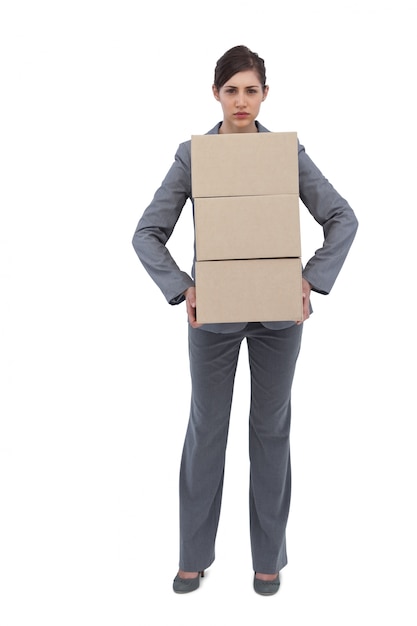 Mulher de negócios séria carregando caixas de papelão