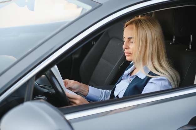 Mulher de negócios séria no carro examina documentos importantes