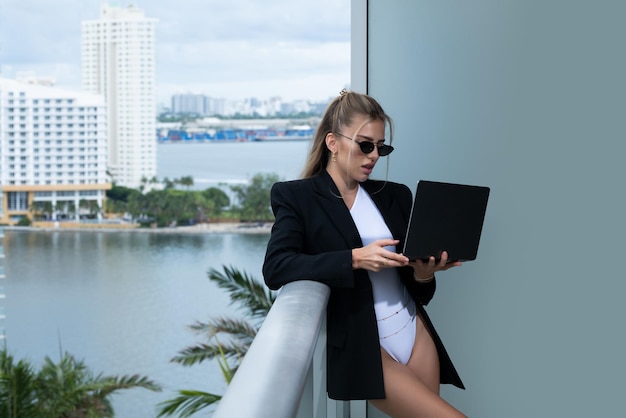 Mulher de negócios sexy linda secretária com laptop empresária sexy em um terno ao ar livre de