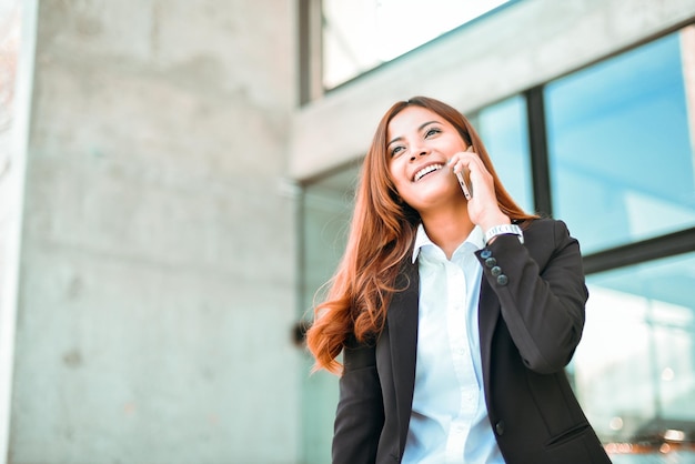 Foto mulher de negócios sorridente a falar ao telemóvel.