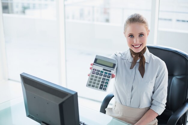 Mulher de negócios sorridente mostrando calculadora