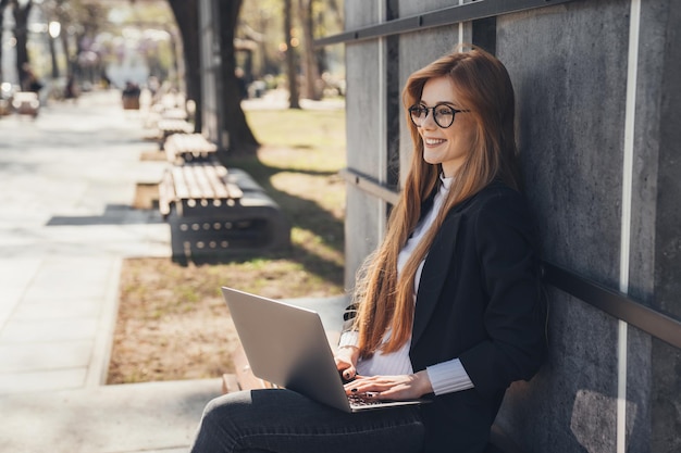 Foto mulher de negócios sorridente trabalhando no laptop em local público no banco conceito de tecnologia tablet notebook teletrabalho teletrabalho zenital