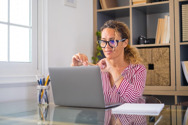 Mulher de negócios sorridente usando laptop no escritório