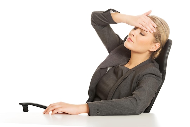 Foto mulher de negócios tensa sentada em uma mesa contra um fundo branco