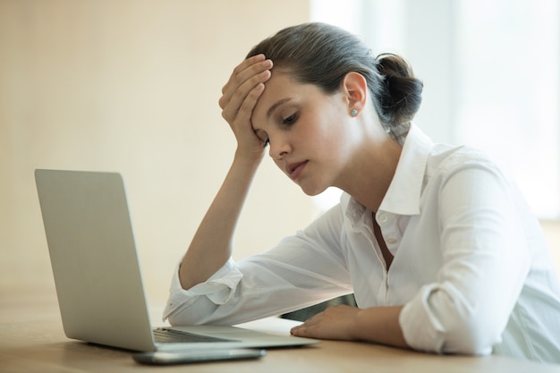 Mulher de negócios tensa usando laptop na sala de conferências