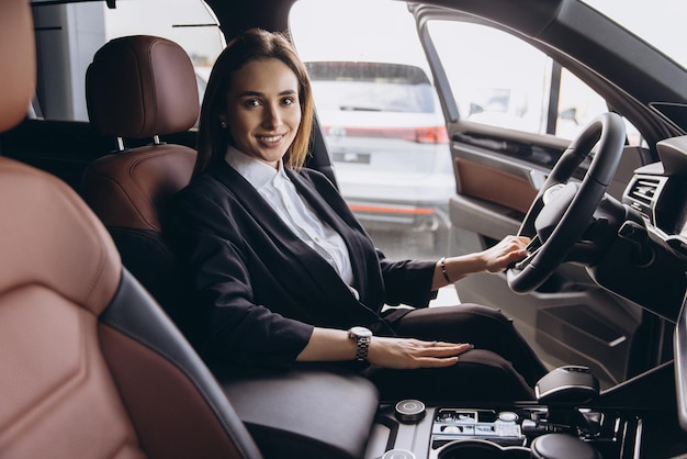 Mulher de negócios testando um carro novo em uma concessionária