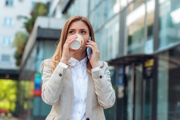 Mulher de negócios tomando café e falando no telefone