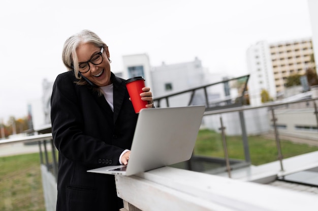 Mulher de negócios trabalhando ao ar livre com laptop e xícara de café