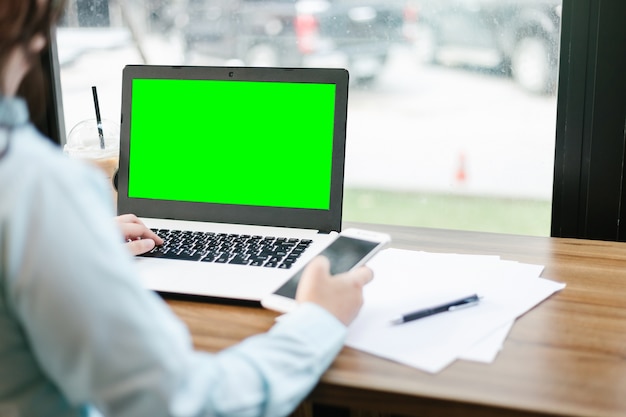 Mulher de negócios, trabalhando com a imagem de maquete do laptop com tela verde em branco, fazer uma nota