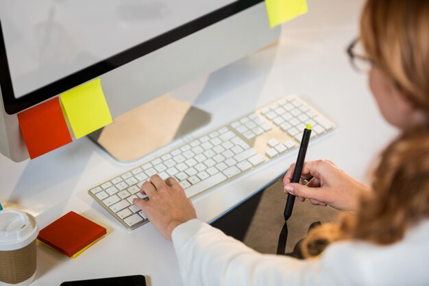 Mulher de negócios trabalhando com mesa digitalizadora na mesa