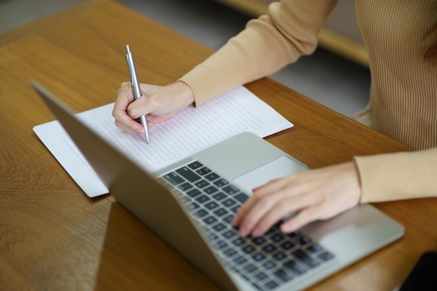 Mulher de negócios trabalhando em casa, trabalho on-line no laptop Empresária asiática, trabalhando no sofá, negócios on-line com reunião on-line de laptop com distanciamento social