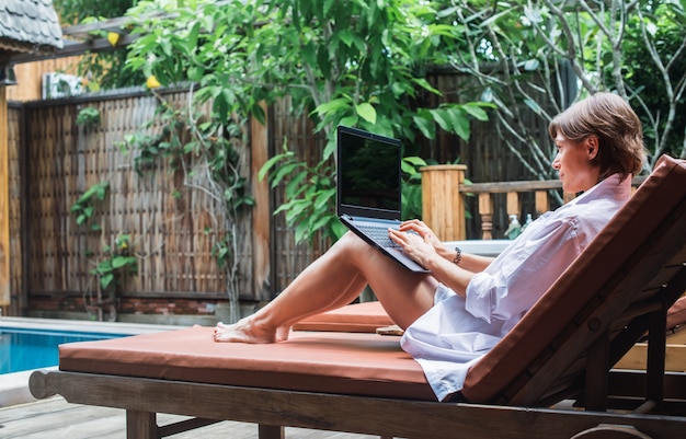 Mulher de negócios trabalhando no computador ao ar livre nas férias