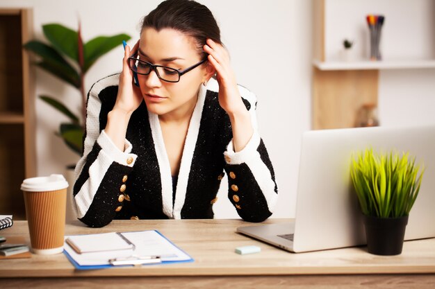 mulher de negócios, trabalhando no laptop em sua estação de trabalho.