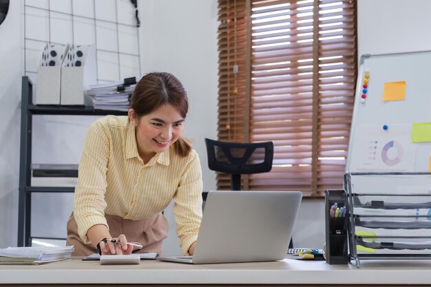 Foto mulher de negócios usa calculadora para calcular finanças matemática na mesa no escritório e nos negócios