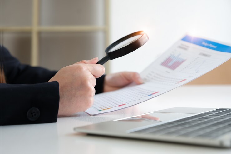 Foto mulher de negócios usando a ampliação para revisar o balanço anual. auditar e verificar a integridade antes do conceito de investimento.