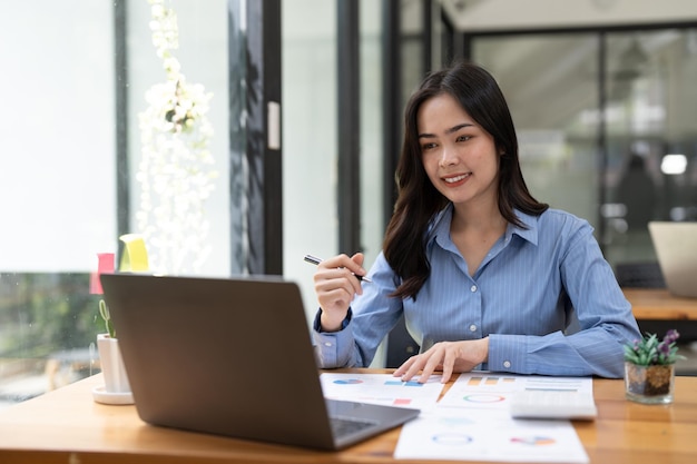 Mulher de negócios usando calculadora para fazer finanças matemáticas na mesa de madeira no escritório e negócios trabalhando estatísticas de contabilidade tributária e conceito de pesquisa analítica