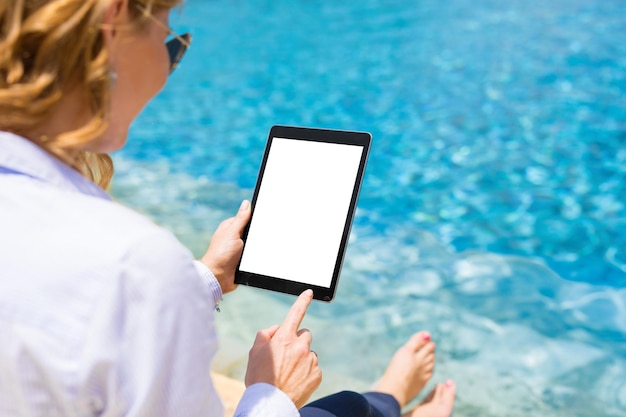 Mulher de negócios usando computador tablet à beira da piscina