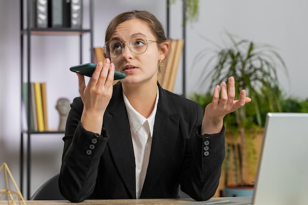 Foto mulher de negócios usando laptop enquanto está sentada na mesa