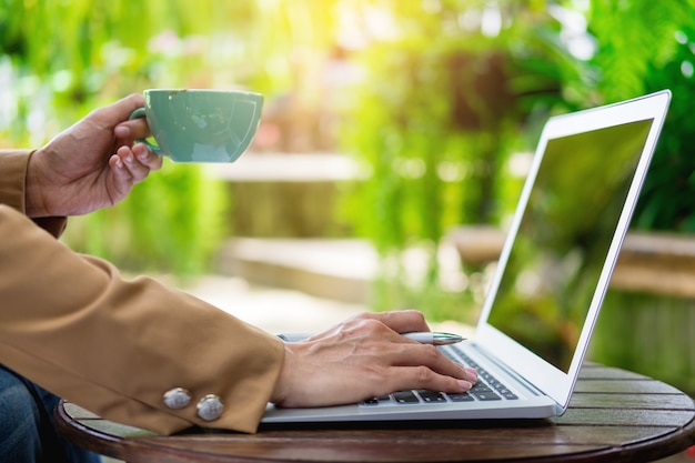 Mulher de negócios usando laptop na mesa no jardim