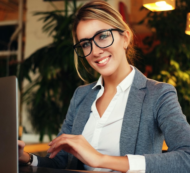 Mulher de negócios usando laptop no café Jovem linda sentada em uma cafeteria e trabalhando no computador