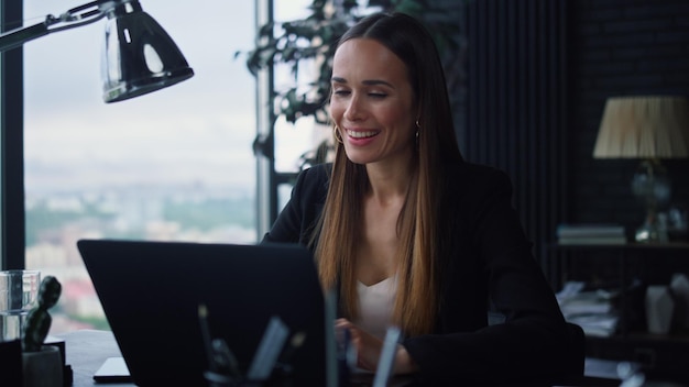 Mulher de negócios usando laptop para trabalhar no escritório Garota positiva apontando para a tela