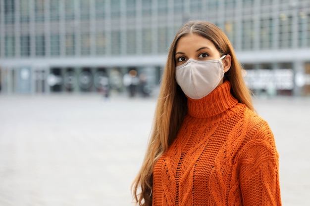 Mulher de negócios usando máscara protetora em pé na rua