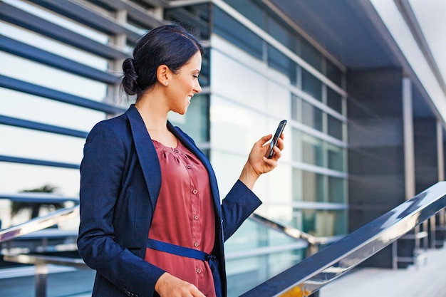 Mulher de negócios usando o telefone ao ar livre