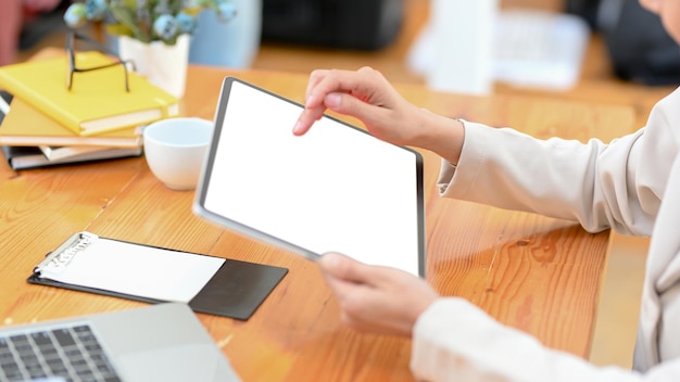 Mulher de negócios usando o touchpad digital portátil em sua maquete de tela branca de mesa de escritório