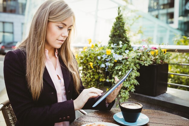 Mulher de negócios usando seu tablet pc no café