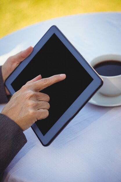 Mulher de negócios usando tablet com café