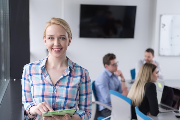 Mulher de negócios usando Tablet Digital no escritório corporativo pela janela