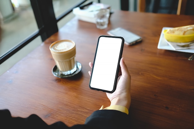 Mulher de negócios usando telefone celular móvel com tela de toque verde no café. Compartilhando mensagens nas mídias sociais.