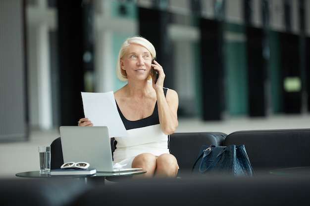 Mulher de negócios usando telefone celular no trabalho