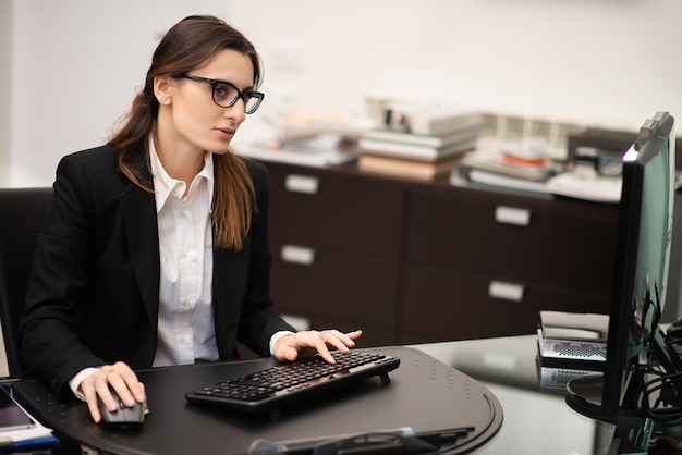 Foto mulher de negócios usando um tablet em seu escritório moderno, conceito de carreira de empresária