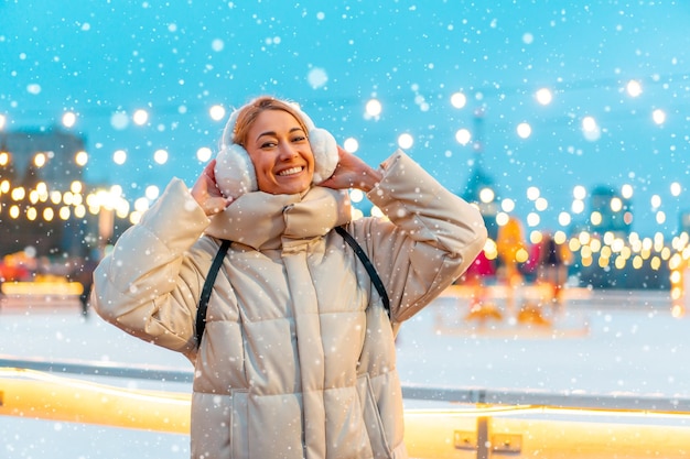 Mulher de noite de férias de Natal de inverno do lado de fora e sorria