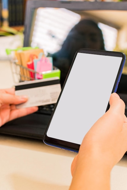 Mulher de pagamento on-line mãos com telefone inteligente e usando cartão de crédito para compras on-line