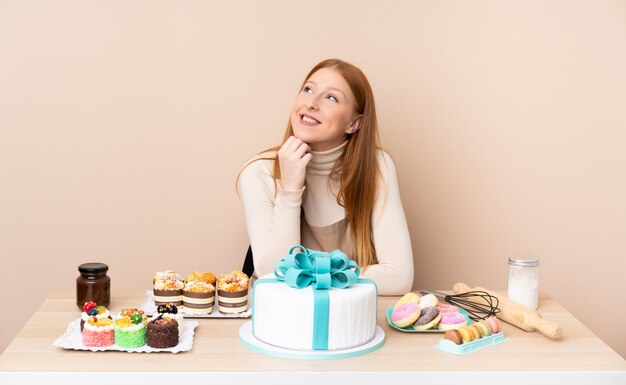 Mulher de pastelaria com mesa cheia de doces